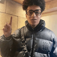 a young man wearing glasses and a jacket that says lacoste on it