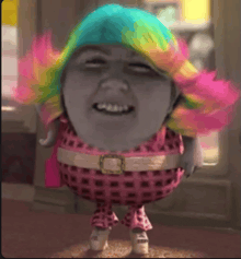a troll with a rainbow hair and a pink outfit is smiling