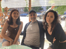 a man and two women posing for a picture in front of a window