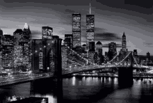 a black and white photo of a city skyline at night with the twin towers in the background .