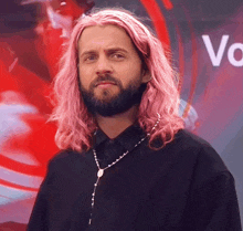 a man with long pink hair and a beard wears a rosary