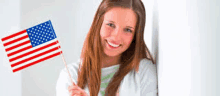 a young woman is holding an american flag in her hand .