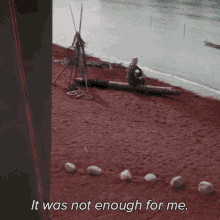 a man sits on a log on a beach with the words " it was not enough for me " below him