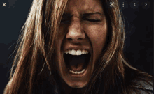 a woman is screaming with her eyes closed and her mouth open