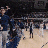 a basketball game is being played in front of a crowd and a sign that says welcome to the fieldhouse