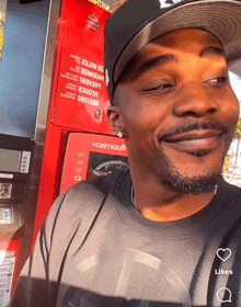 a man is smiling in front of a gas pump that says ' a ' on it