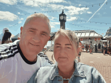 a man and a woman are posing for a picture in front of a sign that says exit only