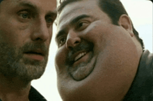 two men are looking at each other with one having a very large face