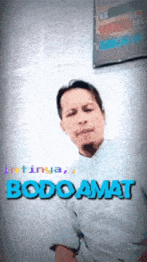 a man is standing in front of a wall with the word bodo amat written on it