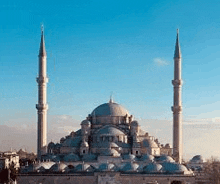 a large mosque with two minaret tower against a blue sky .