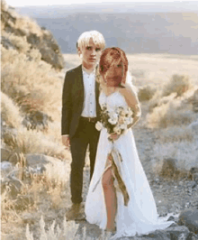 a bride and groom are posing for a picture in the desert .