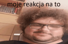 a man with glasses and a beard has the words moje reakcja na to written on his face