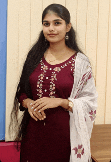 a woman with long hair is wearing a maroon dress