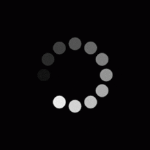 a black and white loading circle with gray circles on a black background .