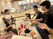 a chick-fil-a bag sits on a table with a group of people