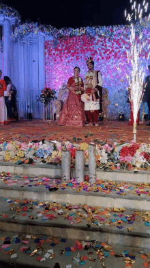 a bride and groom are standing on a stage surrounded by confetti