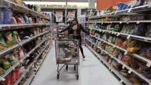 a woman pushing a shopping cart in a grocery store aisle with a sign that says you for shopping with us