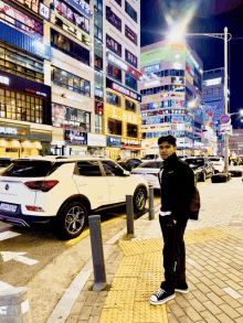 a man stands on a sidewalk in front of a building that says starbucks