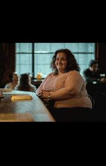 a woman sits at a bar with her arms crossed