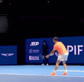 a man is holding a tennis racquet on a tennis court in front of an atp ad .