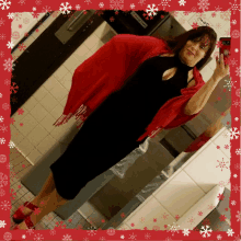 a woman in a black dress and red scarf is taking a selfie in a bathroom