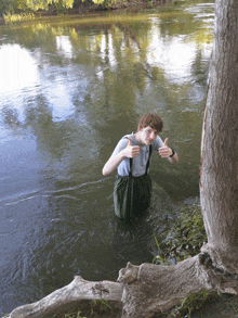 a young man giving a thumbs up while standing in the water