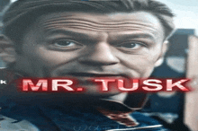 a close up of a man 's face with the name mr. tusk written in red