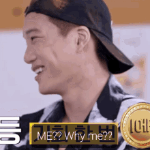 a man wearing a baseball cap is smiling with the words me ? why me ? below him