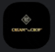 a close up of a black square with a gold logo on it