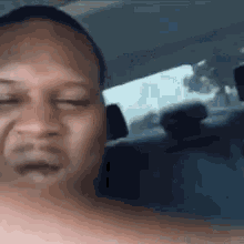 a shirtless man is sitting in the back seat of a car .