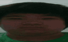 a blurry picture of a person 's face with a green shirt