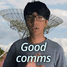 a man says good comms in front of a satellite dish