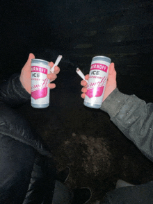 two people are holding a can of smirnoff ice raspberry