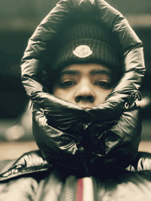 a man wearing a black beanie with the word moncler on the front