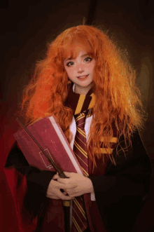 a girl in a harry potter costume is holding a book and wand