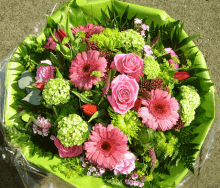 a bouquet of pink and green flowers wrapped in plastic