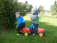 two young boys are playing with toys in the grass and the date of the photo is 28.06.2014