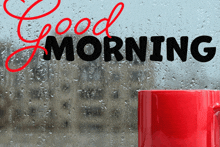 a red coffee mug sits in front of a window with the words good morning written on it