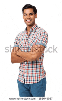 a young man is standing with his arms crossed and smiling for the camera .