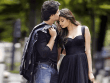 a man kisses a woman on the forehead while standing next to her