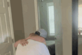 a man in a hat is hugging another man in a hallway .