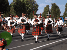 a group of men in kilts march down the street