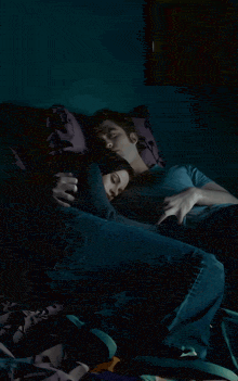 a man and a woman are laying on a couch and the woman is sleeping