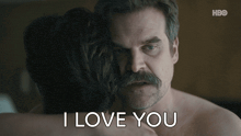 a man with a mustache is hugging a woman with the words i love you written below him
