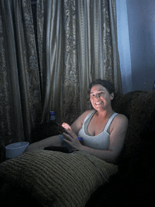 a woman sits on a couch with a can of bud light