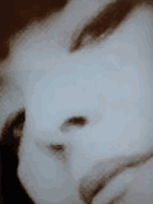 a close up of a person 's face with a blurred image