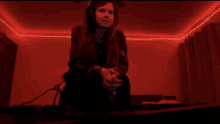 a young girl wearing headphones sits in a dark room