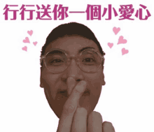 a man with glasses is making a heart with his fingers