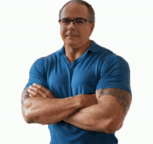 a man with glasses and a tattoo on his arm is standing with his arms crossed