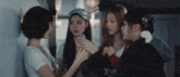 a group of girls are standing around looking at a cell phone